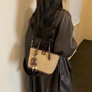 Retro canvas bucket bag for women, chic shoulder bag with flower charm, daily commute.
