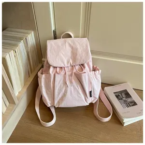 Vue détaillée d'un sac à dos rose décontracté en tissu avec cordon et poches latérales.
