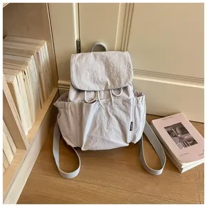 Vue détaillée du sac à dos léger pour femme en tissu, avec cordon de serrage et poches.