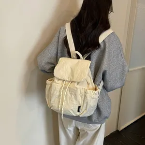 Vue détaillée du sac à dos en toile décontracté avec fermeture à cordon et poches avant.