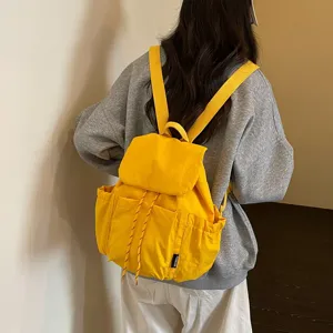 Vue detail sac a dos, tissu jaune decontracté, grande capacite pour voyage et ecole.