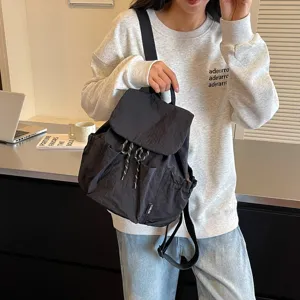 Sac à dos décontracté noir en nylon pour femmes, élégant sac de voyage quotidien avec cordon.