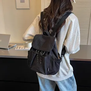 Détail du sac à dos décontracté en tissu noir avec poches pratiques et bretelles confortables.