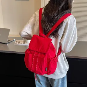 Sac à dos élégant en tissu rouge pour femme, grand sac de voyage décontracté pour usage quotidien.