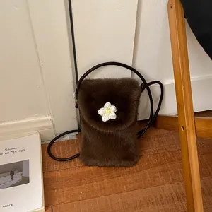 Dark brown plush mini phone bag with cute white crochet flower, chic crossbody shoulder bag for women.