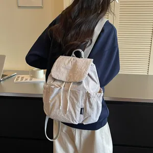 Vue détaillée d'un sac à dos en tissu pour femme avec effet de dos et poches pratiques.