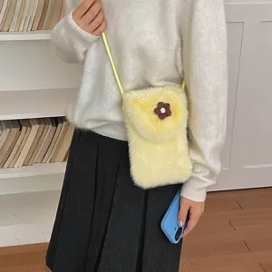 Fluffy plush phone bag detail shot, cute yellow crossbody mini bag with brown flower accent.