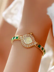 Luxury emerald green crystal quartz watch detail showing elegant geometric dial and sparkling rhinestones.