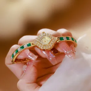 Elegant gold square quartz wristwatch for women featuring green and white crystal gemstone band.