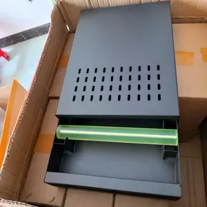 Detail view of the commercial drawer type coffee knock box with green bar and ventilation holes.