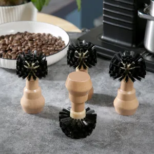 Nahaufnahme von Espressomaschinen-Gruppenkopf-Reinigungsbürsten mit Holzgriff und schwarzen Borsten.