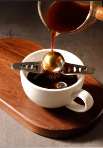 Stainless steel coffee flow control ball and holder detail shot for pour-over coffee brewing.