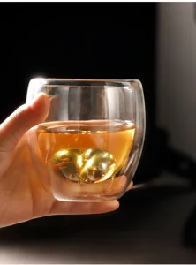 Stainless steel coffee ice ball detail shot showing metallic gold sphere inside glass.