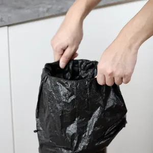 Black plastic trash bag liner for coffee knock box bucket, durable material with drawstring.
