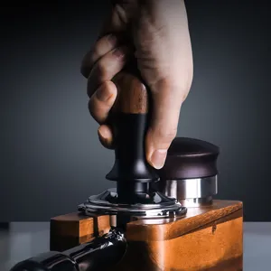 Walnut coffee constant force tamper with wooden base for espresso making and barista tools.