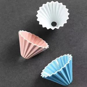Detailed shot of ceramic origami coffee dripper, cone drip filter cup in white, pink, blue.