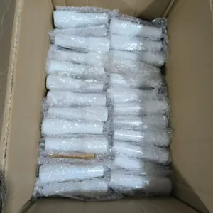 Coffee machine handle detail view, white ABS replacement part packed securely in box.