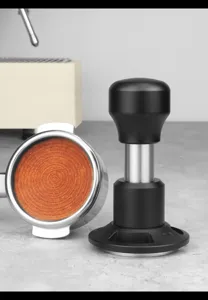 Détail de tamper à café professionnel et porte-filtre pour expresso, construction en métal de qualité.