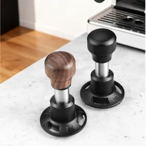Vue détaillée de tasseurs à café calibrés avec des poignées en bois et noires pour expresso.