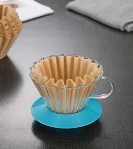 Glass pour over coffee dripper with blue base and brown wave filter paper for brewing.
