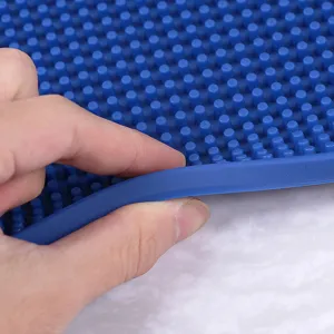 Dettaglio del tappetino da bar in gomma blu, con materiale flessibile e perni antiscivolo.
