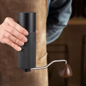 Moulin à café manuel avec corps en aluminium, poignée en métal et bouton en bois pour grains.