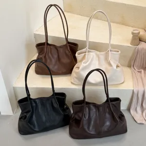 Close-up view of multiple colors minimalist PU leather shoulder tote bags displayed neatly.