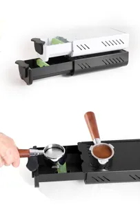 Vista dettagliata del cassetto raccogli fondi caffè con portafiltro in legno e base pressatura.