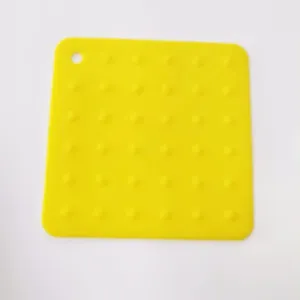 Gelbe quadratische Silikon-Hitzeschutzmatte Detail, Noppen und Aufhängeloch für Küche.