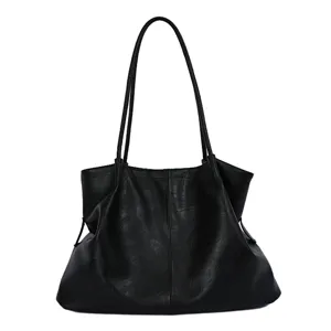 Detail view of the soft black leather tote bag with slim double shoulder straps and slouchy design.
