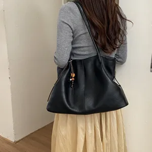 Detailed view of women large black leather slouchy tote bag, casual daily shoulder handbag.