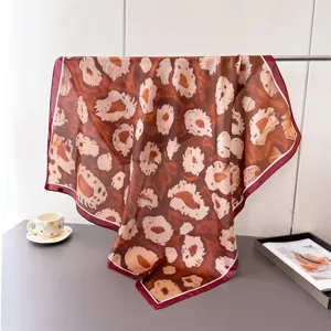 Detailed shot of the chic leopard print imitation silk square scarf, elegant drape and fabric texture.