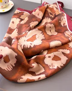 Detailed shot of a vintage leopard print imitation silk square scarf draped gracefully.