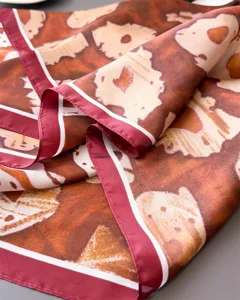 Close-up detail of a vintage leopard print square silk scarf with a dark red border.