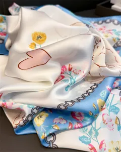 Gros plan d'un grand carré de soie avec motif de lapin et fleurs montrant la texture.