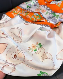 Gros plan détaillé du foulard en satin motif lapin et fleurs, montrant une texture soyeuse.