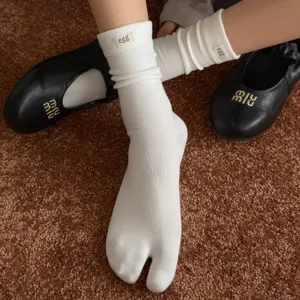 Women's white split-toe crew socks with cute cuff label, cozy autumn hosiery for daily wear.