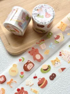 Close-up detail of cute cartoon washi tape rolls with bear and cat patterns for journaling.