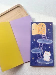 Close-up detail of TN planner notebook with colorful inner pages and cute starry cat cover.
