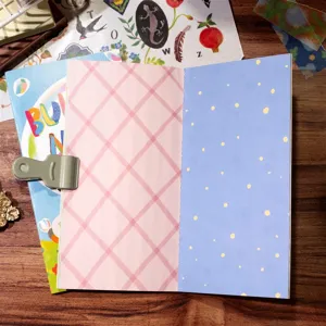 Detailed view of TN notebook inner pages featuring grid and polka dot patterns with a green clip.