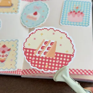 Close-up detail of pixel art strawberry cake sticker stationery, cute aesthetic planner decor.
