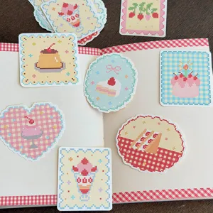 Detailed close-up view of cute pixel art dessert theme stickers and sticky notes on a notebook.