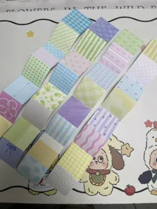 Detail shot of colorful scrapbook paper strips with various plaid, dot, and floral patterns.