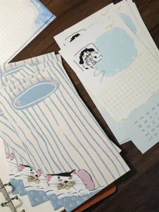 Detailed shot of cute cat illustration loose-leaf planner inner pages with grid and calendar.