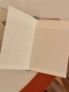 Detaillierte Nahaufnahme der geöffneten linierten Innenseiten dieses süßen Notizbuchs.