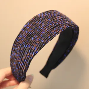 Gros plan sur le détail du serre-tête plissé avec motif à pois bleus et texture douce.
