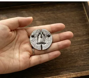 Primo piano dei dettagli della spilla rotonda in metallo in stile tibetano vintage.
