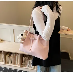 Detalle de bolso tote informal rosa con gran capacidad, diseño elegante y lindo colgante.