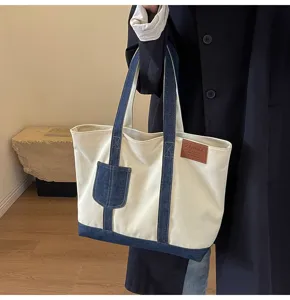 Λεπτομέλεια τσάντας tote από καμβά, denim patchwork, λουράκι, τσέπη και δερμάτινο λογότυπο