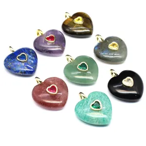 Pendentifs cœur en pierre naturelle assortis avec détails en zircone dorée, vue en gros plan.